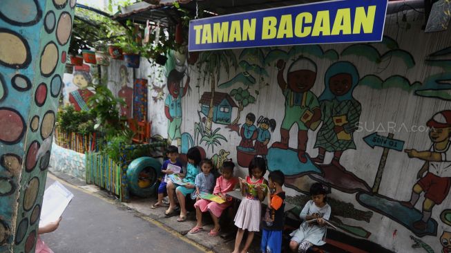 Sejumlah anak membaca di Taman Bacaan di kawasan Jembatan Lima, Jakarta,  Kamis (13/2).  [Suara.com/Angga Budhiyanto]