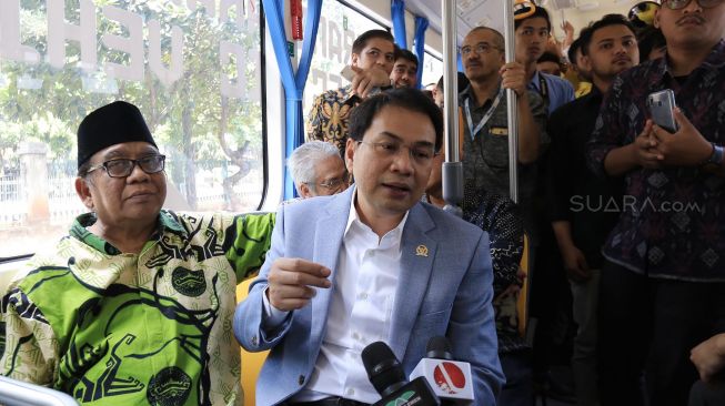 Wakil Ketua DPR Koordinator Bidang Politik, Hukum dan Keamanan, Azis Syamsuddin (kanan) dan Ketua Umum Lembaga Dakwah Islam Indonesia (LDII), Abdullah Syam (kiri) berbincang kepada wartawan saat mencoba Bus listrik yang digagas LDII, Rabu (12/02). [Suara.com/Oke Atmaja]