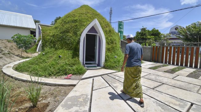 Seorang laki-laki berjalan menuju musholla berbentuk rumah dome di Kecamatan Pemenang, Tanjung, Lombok Utara, NTB, Rabu (12/2). [ANTARA FOTO/Ahmad Subaidi]
