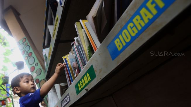 Sejumlah anak memilih buku di Taman Bacaan di kawasan Jembatan Lima, Jakarta,  Kamis (13/2). [Suara.com/Angga Budhiyanto]