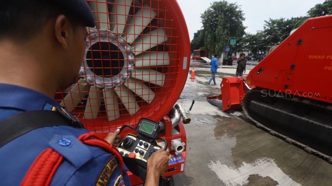 Petugas Pemadam Kebakaran mengoperasikan Robot damkar LUF60 saat demonstrasi robot pemadam kebakaran di Halaman Dinas Pemadam Kebakaran DKI Jakarta, Kamis (13/2). [Suara.com/Angga Budhiyanto]  