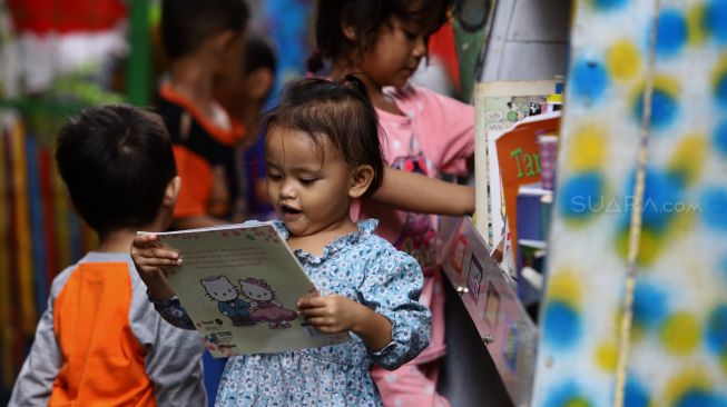 Seorang anak memilih buku di Taman Bacaan di kawasan Jembatan Lima, Jakarta,  Kamis (13/2). [Suara.com/Angga Budhiyanto]