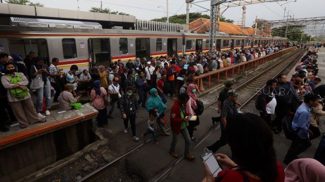 Rangkaian kereta rel listrik (KRL) menaikkan dan menurunkan penumpang di Stasiun Manggarai, Jakarta, Kamis (13/2). [Suara.com/Angga Budhiyanto] 