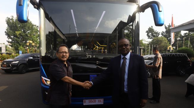 Presiden terpilih Guinea-Bissau Umaro Cissoko Embalo (kanan) bersalaman dengan Technical Director PT. Mobil Anak Bangsa Bambang Tri Soepandji (kiri) di depan bus Mobil Anak Bangsa (MAB) menuju Bandara Halimperdanakusuma, Jakarta, Jumat (14/2). [Suara.com/Angga Budhiyanto]