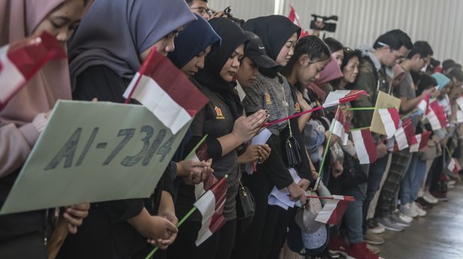 Warga Negara Indonesia (WNI) yang dievakuasi dari Wuhan, Provinsi Hubei, China berdoa bersama usai menjalani masa observasi di Hanggar Pangkalan Udara TNI AU Raden Sadjad, Ranai, Natuna, Kepulauan Riau, Sabtu (15/2). [ANTARA FOTO/Muhammad Adimaja]