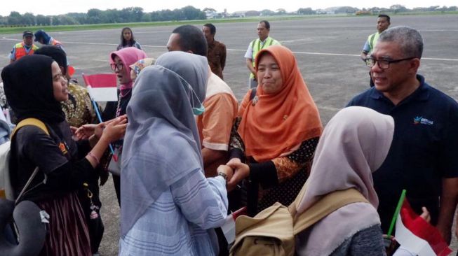 Anggota Komisi IX DPR RI Kurniasih Mufidayati (Hijab orange) bersama rombongan menyalami sejumlah WNI yang telah menjalani observasi Virus Corona di Natuna saat tiba di Bandara Halim Perdana Kusuma, Jakarta Timur, Sabtu (15/2).  [Foto/dok DPR]