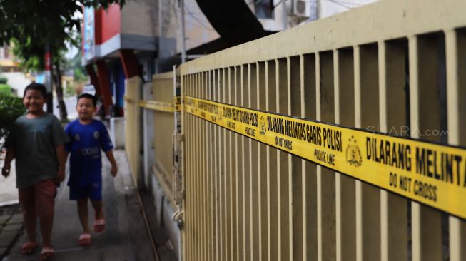 Seorang anak melintas di depan klinik aborsi Paseban, Senen, Jakarta Pusat, Minggu (16/02). [Suara.com/Alfian Winanto]