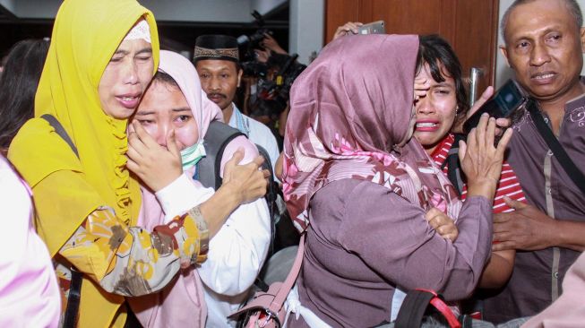 Keluarga menyambut WNI yang telah menjalani masa karantina selama 14 hari di Natuna, Kepulauan Riau, di ruang kedatangan gedung VIP Terminal 1 Bandara Internasional Juanda, Surabaya, Jawa Timur, Sabtu (15/2) malam. [ANTARA FOTO/Umarul Faruq]