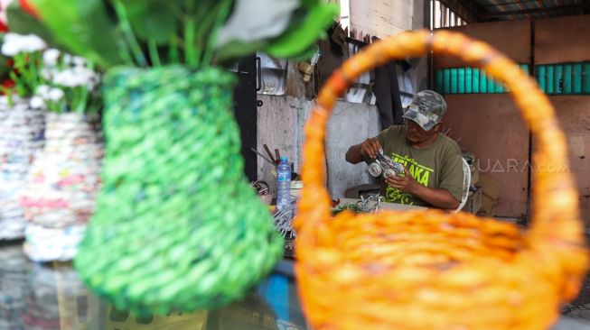 Pak Roni yang membuat karajinan tangan di toko miliknya di Kemandoran VIII, Jakarta Selatan, Senin (17/02). [Suara.com/Alfian Winanto]