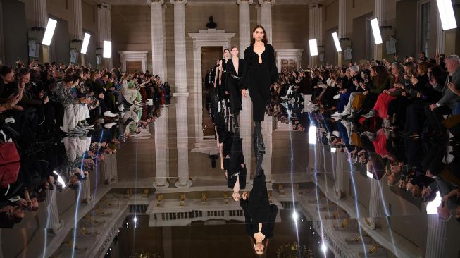 Model berjalan diatas Catwalk membawakan busana rancangan Victoria Beckham pada London Fashion Week di London, Minggu (16/2). [DANIEL LEAL-OLIVAS / AFP]