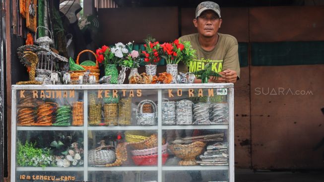 Pak Roni didepan tokonya Original PaperCraft yang membuat kerajinan tangan dari limbah bekas kertas di Kemandoran VIII, Jakarta Selatan, Senin (17/02). [Suara.com/Alfian Winanto]
