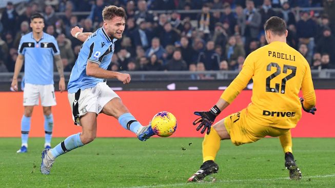 Pemain depan Lazio Ciro Immobile (kiri) menembak ke arah gawang dan di blok kiper Inter Milan Daniele Padelli selama pertandingan sepak bola Serie A Italia, Lazio melawan Inter Milan di Stadion Olimpiko, Roma, Italia, Senin (17/2) dini hari WIB. [Andreas SOLARO / AFP]