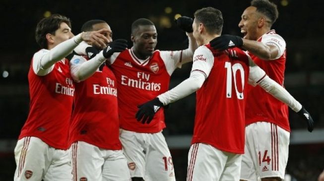 Para pemain Arsenal merayakan gol Arsenal Mesut Ozil (kedua kanan) ke gawang Newcastle United di Emirates Stadium. Ian KINGTON / AFP