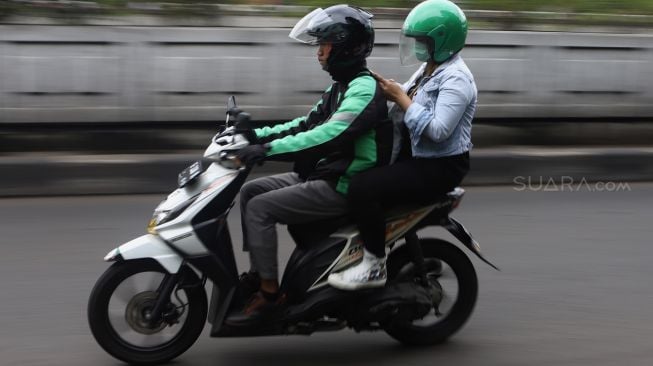 Pengemudi ojek online membawa penumpang melintas di kawasan Pasar Minggu, Jakarta Selatan, Senin (17/2). [Suara.com/Angga Budhiyanto]