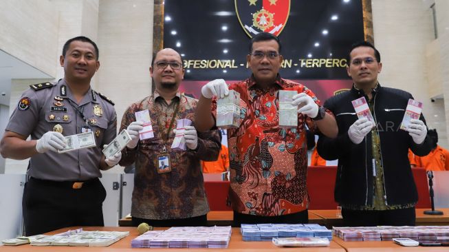 Direktur Dirtipideksus Brigadir Jendral Daniel Monang (kedua kanan) saat menunjukan barang bukti sejumlah uang palsu yang disita di Bareskrim Mabes Polri, Jakarta Selatan, Selasa (18/02). [Suara.com/Alfian Winanto]