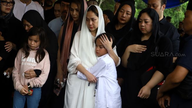 Bunga Citra Lestari memeluk anaknya Noah Sinclair yang saat prosesi pemakaman Ashraf Sinclair di kompleks pemakaman San Diego Hills, Karawang, Jawa Barat, Selasa (18/2). [Suara.com/Angga Budhiyanto]
