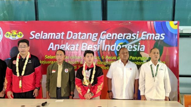 Menteri Pemuda dan Olahraga (Menpora) Zainudin Amali menyambut kepulangan rombongan lifter muda Indonesia yang sukses meraih 16 medali emas di ajang Kejuaraan Angkat Besi Asia Junior dan Remaja 2020 di Bandar Udara Soekarno-Hatta, Tangerang, Banten, Rabu (19/2/2020). (Suara.com / Arief Apriadi) 