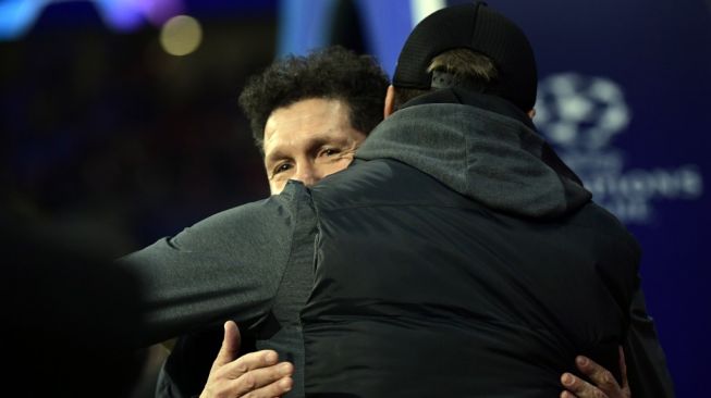 Pelatih Liverpool, Jurgen Klopp (kanan) memeluk pelatih Atletico Madrid, Diego Simeone jelang laga Liga Champions 2019/2020 antara kedua tim di Estadio Wanda Metropolitano, Madrid, Rabu (19/2/2020) dini hari WIB. [JAVIER SORIANO / AFP]