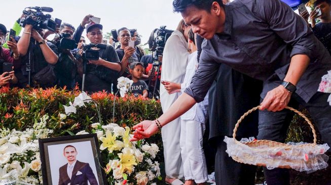 Vokalis group band Noah, Nazril Irham atau Ariel menaburkan bunga di makam almarhum Ashraf Daniel Mohammed Sinclair suami dari penyanyi Bunga Citra Lestari di San Diego Hills Memorial Park, Karawang, Jawa Barat, Selasa (18/2). [ANTARA FOTO/M Ibnu Chazar]
