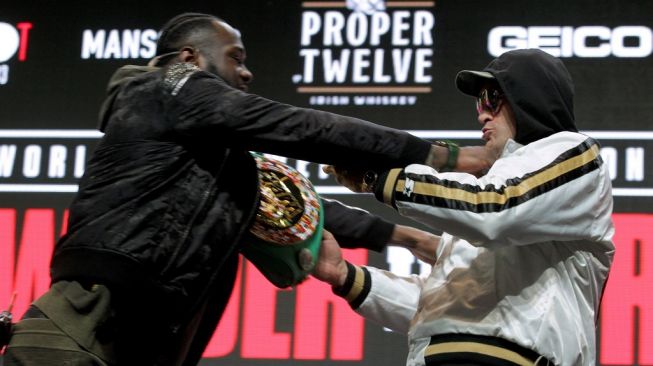 Deontay Wilder (kiri) dan Tyson Fury terlibat saling dorong dalam konferensi jelang duel ulang mereka di MGM Grand Garden Arena, Las Vegas, Rabu (19/2/2020). [AFP/John Gurzinski]