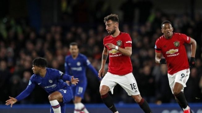 Pemain Manchester United Bruno Fernandes menggiring bola melewati pemain Chelsea dalam pertandingan Liga Inggris yang digelar di Stamford Bridge, 17 Februari 2020. [AFP]