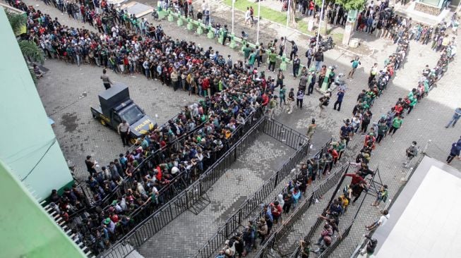 Suporter sepak bola mengantre untuk membeli tiket final pertandingan Piala Gubernur Jawa Timur di Gelora Delta, Sidoarjo, Jawa Timur, Kamis (20/2). [ANTARA FOTO/Umarul Faruq]