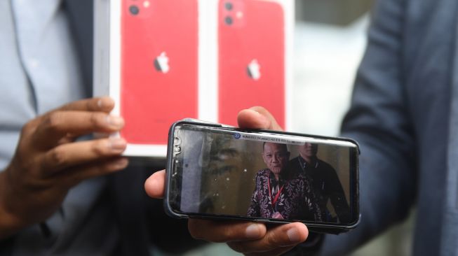 Koordinator Masyarakat Anti Korupsi Indonesia (MAKI) Boyamin Saiman menunjukkan dua buah Iphone 11 untuk pemberi informasi keberadaan DPO KPK Harun Masiku dan Nurhadi di Gedung KPK, Jumat (21/2). [ANTARA FOTO/Akbar Nugroho Gumay]