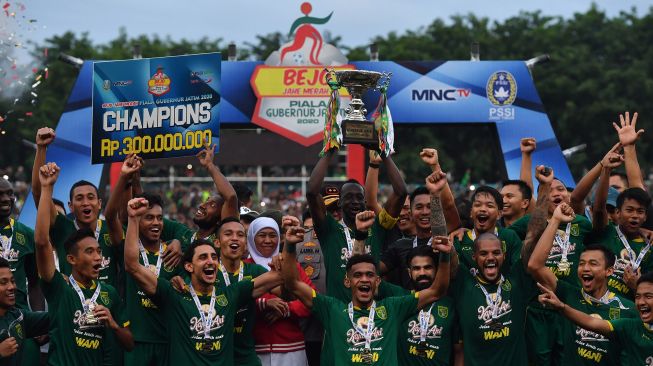 Gubernur Jawa Timur Khofifah Indar Parawansa (tengah) bersama tim Persebaya melakukan selebrasi usai menyerahkan Piala Gubernur Jawa Timur 2020 di Stadion Gelora Delta Sidoarjo, Jawa TImur, Kamis (20/2). [ANTARA FOTO/Zabur Karuru]