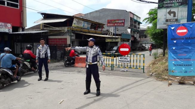 Petugas Dishub Kota Bekasi mengalihkan pengguna jalan. [Suara.com/Yacub]