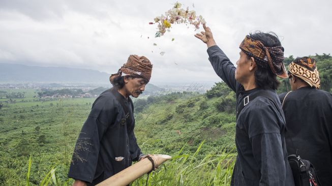 Warga kampung adat Cireundeu menabur bunga saat upacara adat peringatan Hari Peduli Sampah Nasional (HPSN) 2020 di lokasi tragedi longsor sampah eks TPA Leuwigajah, Cimahi, Jawa Barat, Jumat (21/2). [ANTARA FOTO/M Agung Rajasa]