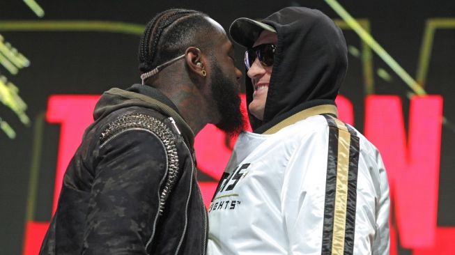 Deontay Wilder (kiri) dan Tyson Fury saling mengintimidasi usai konferensi jelang duel ulang mereka di MGM Grand Garden Arena, Las Vegas, Rabu (19/2/2020). [AFP/John Gurzinski]