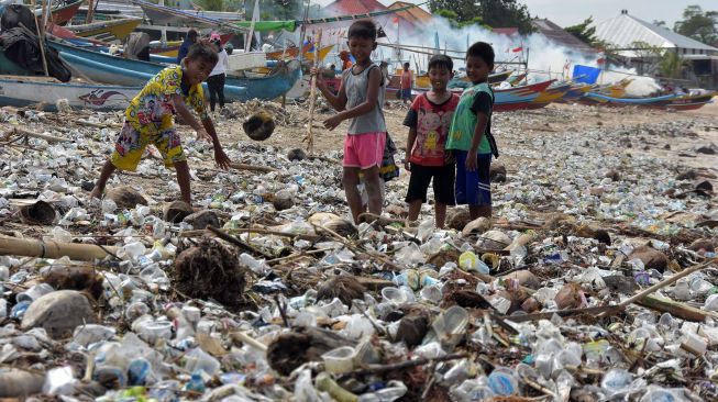 Sejumlah anak bermain di tengah tumpukan sampah yang menumpuk di Pantai Kedonganan, Badung, Bali, Jumat (21/2). [ANTARA FOTO/Nyoman Hendra Wibowo]