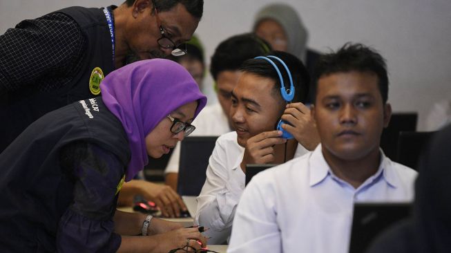 Petugas membantu peserta berkebutuhan khusus saat tes Seleksi Kemampuan Dasar (SKD) Calon Pegawai Negeri Sipil (CPNS) 2019 di Kantor Wali Kota Jakarta Selatan, Sabtu (22/2).  [ANTARA FOTO/Puspa Perwitasari]
