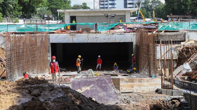 Pekerja menyelesaikan pembuatan jalur  terowongan yang akan menghubungkan Masjid Istiqlal dengan Gereja Katedral di Jakarta Pusat, Minggu (23/02). [Suara.com/Alfian Winanto]
