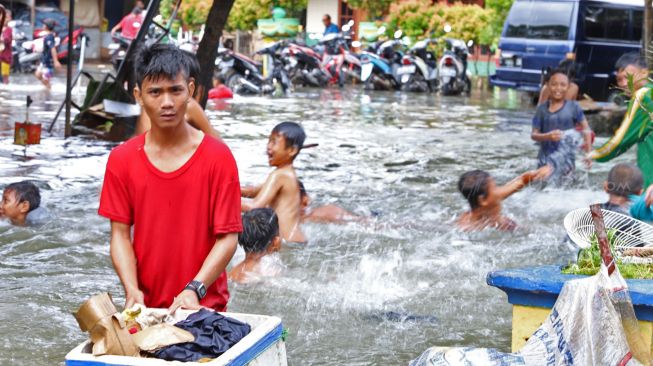 Aktivitas warga saat banjir di Petamburan II, Jakarta Pusat, Minggu (23/02). [Suara.com/Alfian Winanto]