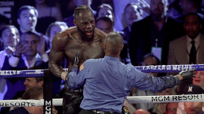 Reaksi petinju AS Deontay Wilder (kiri) usai pertarungannya melawan Tyson Fury di MGM Grand Garden Arena, Las Vegas, Sabtu (22/2/2020), dihentikan pada ronde ketujuh. Fury pun dinyatakan menang TKO. [AFP/Mark Ralston]