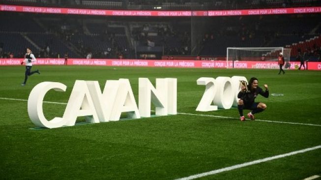 Striker Paris Saint-Germain Edinson Cavani berpose setelah mendapatkan trofi setelah mencetak gol ke-200 untuk timya saat menghadapi Girondins de Bordeaux dalam laga Liga Prancis di Parc des Princes stadium. Martin BUREAU / AFP