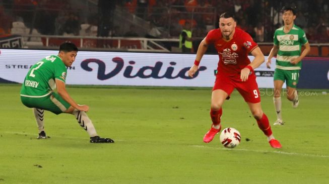 Striker Persija Marco Simic saat mencoba melewati pemain Geylang International FC dalam laga persahabatan di Stadion Utama Gelora Bung Karno, Jakarta, Minggu (24/02). [Suara.com/Alfian Winanto]
