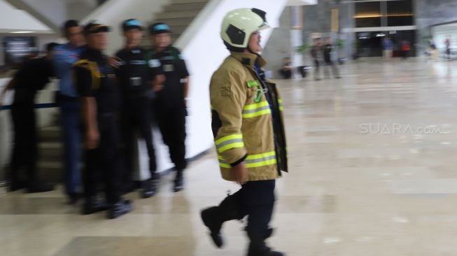 Pemadam kebakaran memantau Gedung Nusantara III DPR RI, Jakarta, Senin (24/2). [Suara.com/Alfian Winanto]