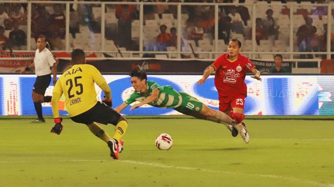 Midfielder Persija Riko Simanjuntak saat melanggar pemain Geylang International FC dalam laga persahabatan di Stadion Utama Gelora Bung Karno, Jakarta, Minggu (24/02). [Suara.com/Alfian Winanto]
