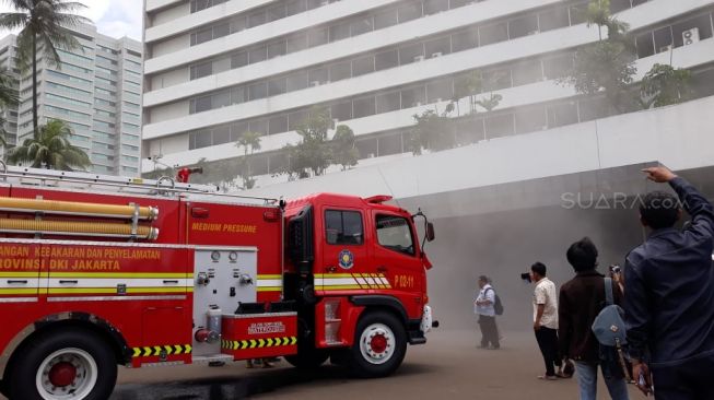 Mobil pemadam kebakaran di Gedung Nusantara III DPR RI yang dipenuhi asap, Jakarta, Senin (24/2).  [Suara.com/Novian]
