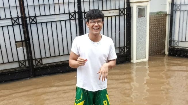 Pemain Amartha HangTuah, Firman Yohanes Situmorang, di pelataran asrama pemain yang dilanda banjir di kawasan Kemang, Jakarta Selatan. [Dok. HangTuah]