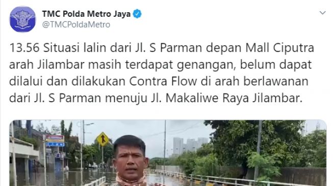 AKBP Dermawan Karosekali melaporkan situasi banjir di Jakarta sambil membawa ular besar.