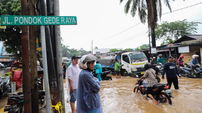 Kondisi Jalan Raya Pondok Gede yang tergenang banjir di Bekasi, Jawa Barat, Selasa (25/02). [Suara.com/Alfian Winanto]