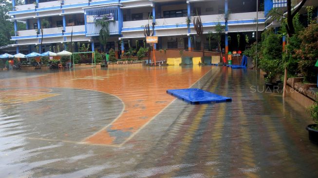 Suasana banjir yang menggenangi sekolah SMPN 8, Jakarta, Selasa (25/2). [Suara.com/Oke  Atmaja]
