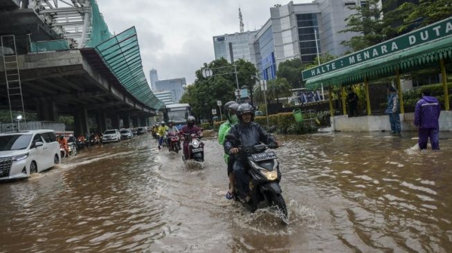 Pengendara melintasi banjir yang menggenangi Jalan H. R. Rasuna Said, Kuningan, Jakarta, Selasa (25/2/2020). Hujan deras sejak Senin dini hari membuat sejumlah daerah di Ibu Kota tergenang banjir. (ANTARA FOTO/Galih Pradipta/wsj.)