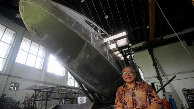 Dosen Institut Teknologi Sepuluh Nopember (ITS), Wisnu Wardhana berpose di samping kapal perang "The Croc" di Laboratorium Kelautan ITS, Surabaya, Jawa Timur, Rabu (26/2).  [ANTARA FOTO/Moch Asim]