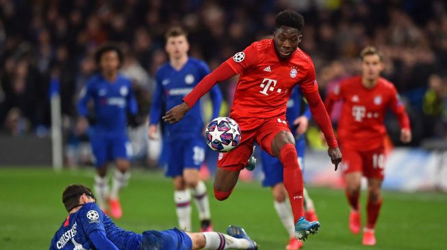 Gelandang Bayern Munich Alphonso Davies mencoba melewati pemain belakang Chelsea dari Andreas Christensen (kiri) selama pertandingan leg pertama babak 16 besar  Liga Champions antara Chelsea melawan Bayern Munich di Stamford Bridge, London, Inggris, Rabu (26/2) dini hari WIB. [Glyn KIRK / AFP]
