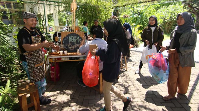 Barista menerima sampah plastik yang ditukarkan dengan kopi di Kampus Unair Banyuwangi, Jawa Timur, Kamis (27/2).  [ANTARA FOTO/Budi Candra Setya]