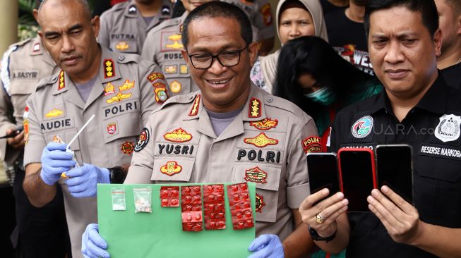 Kabid Humas Polda Metro Jaya Kombes Pol Yusri Yunus (tengah) didampingi Kapolres Jakarta Barat Kombes Pol Audie S Latuheru (kiri) beserta jajaran menunjukkan barang bukti saat gelar perkara kasus narkoba publik figur di Polres Metro Jakarta Barat, Kamis (27/2). [Suara.com/Angga Budhiyanto]